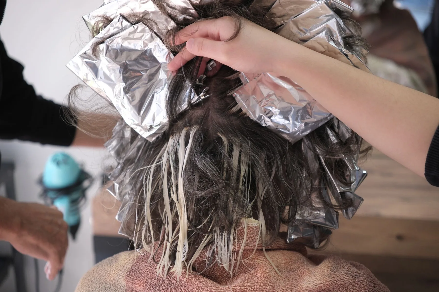Stylist placing foil highlights